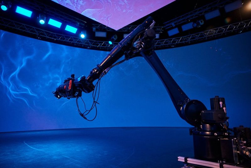 Een Canon EOS C400-camera die is gemonteerd op een kraanarm op een OSVP-set voor een scherm met een wervelend blauw patroon.