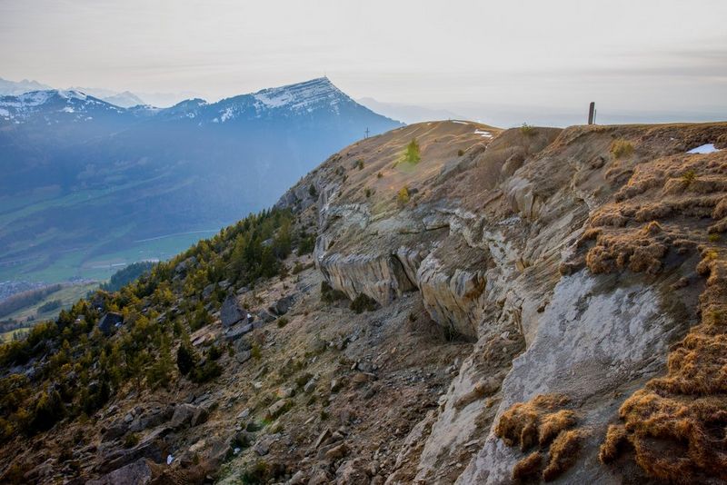 Изображение HDR очень высокого разрешения, на котором запечатлена горная вершина, долина и еще более высокие горы на фоне; снято Мартином Биссигом на камеру Canon EOS R5.