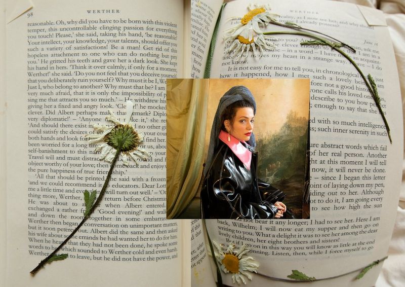 A photograph of Wanda Martin has been digitally added to an image of an open book with four large, pressed flowers scattered across the pages.