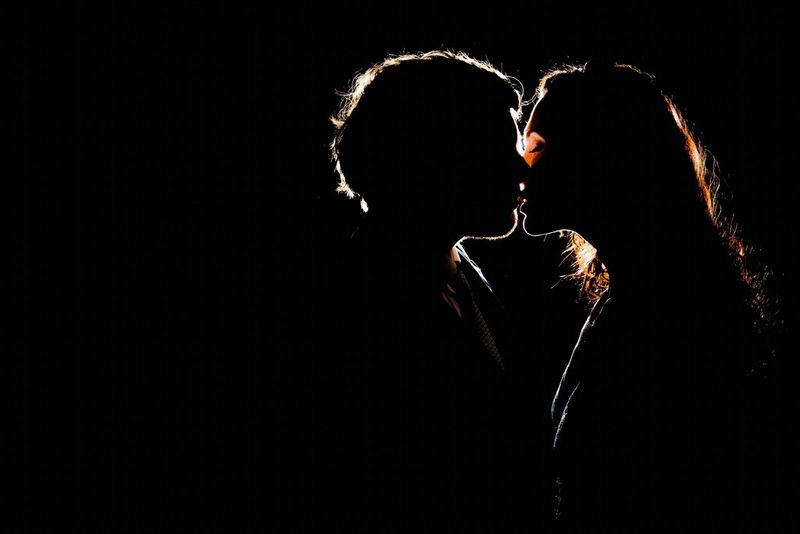 A couple are captured kissing in silhouette against a black background in a photograph taken by Alison Bounce.