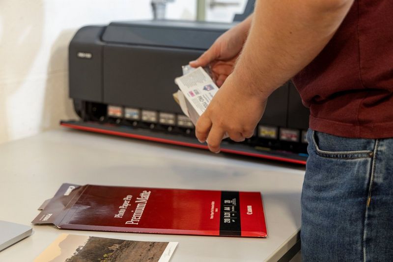 Timo Beke refills the ink and paper on his Canon imagePROGRAF PRO-1100 printer.