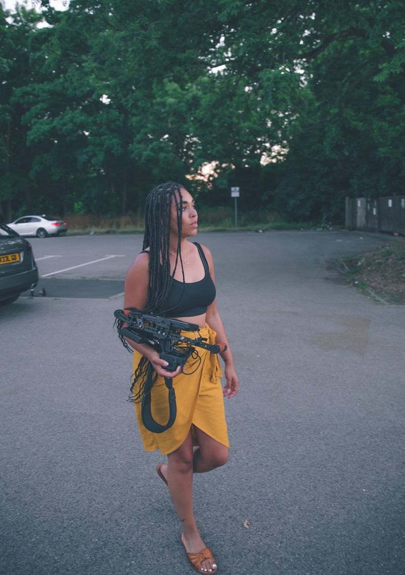 Regisseur Ashleigh Jadee loopt op straat met haar camera in de hand.