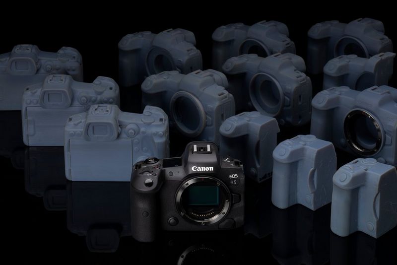 Een Canon EOS R5 met een aantal proefmodellen erachter, waarvan sommige alleen uit het grip-gedeelte van de camera bestaan.