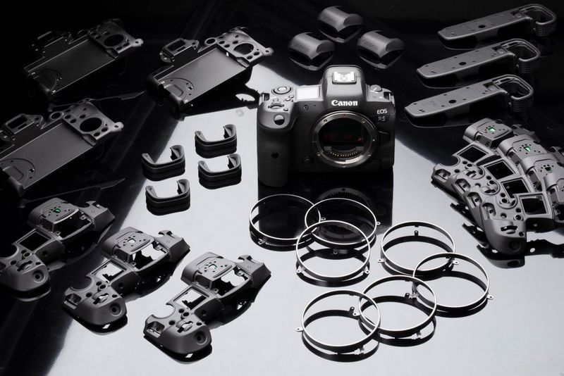 Een Canon EOS R5 omgeven door talrijke onderdelen die bij de constructie zijn gebruikt.