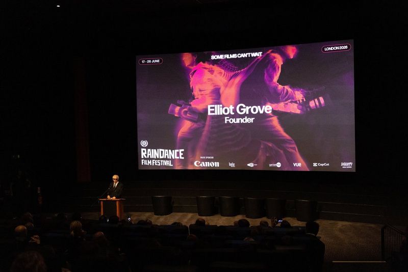 Raindance founder Elliot Grove in front of a film screen at the Raindance Film Festival 2026