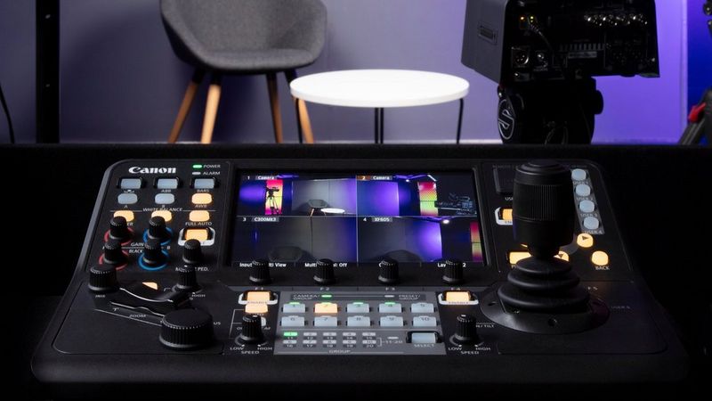 Primo piano dei comandi e dello schermo del controller PTZ Canon RC-IP1000 in uno studio.