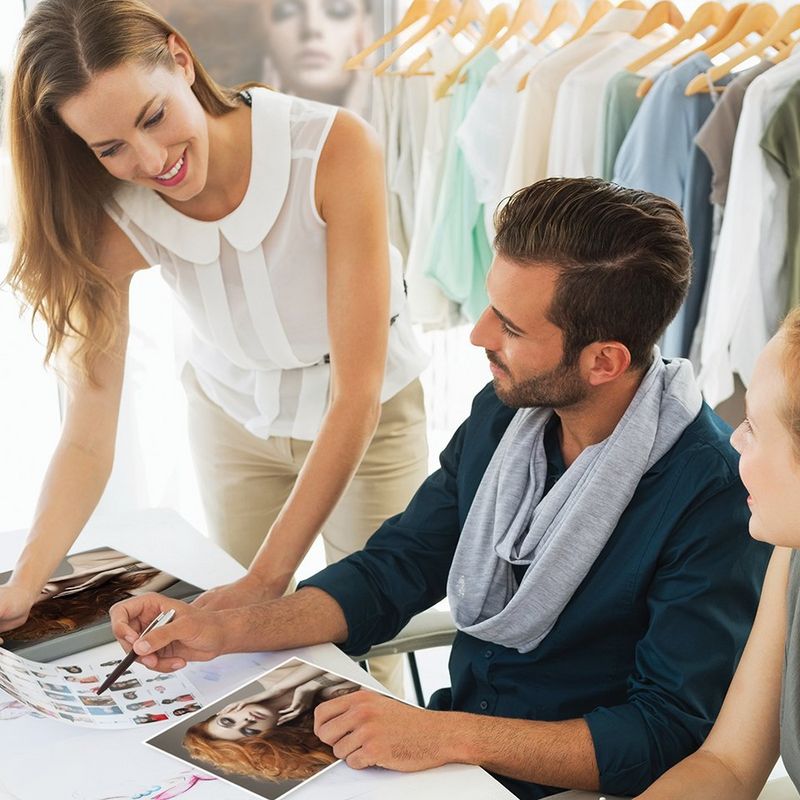 To kvinder og en mand ser på billeder printet på en Canon-maskine.