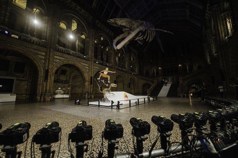 Una selezione di videocamere Canon disposta sul pavimento punta in direzione di una skater che esegue evoluzioni all'interno del Natural History Museum di Londra.