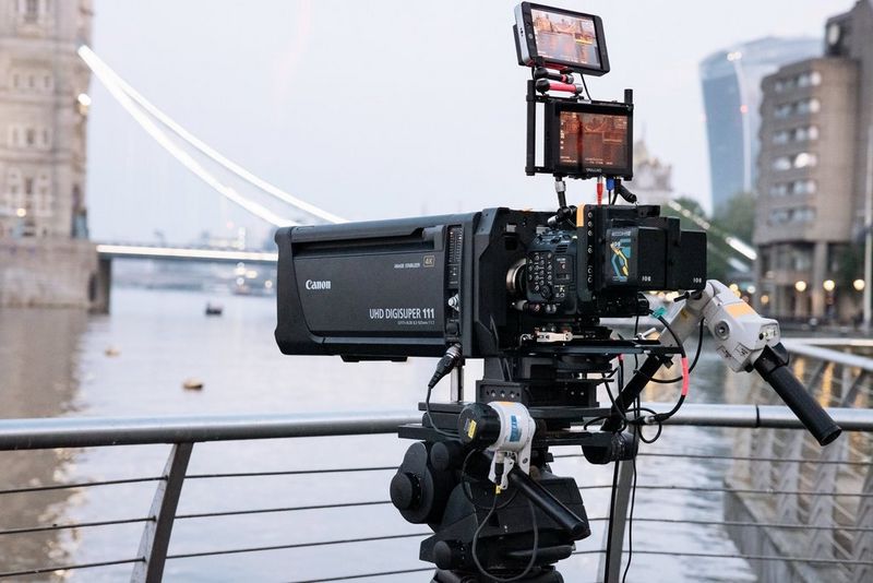 A Canon UJ111x8.3B broadcast lens mounted on a Canon EOS C300 Mark III, with the River Thames and Tower Bridge in the background, ready to capture the Red Bull wingsuit flight.