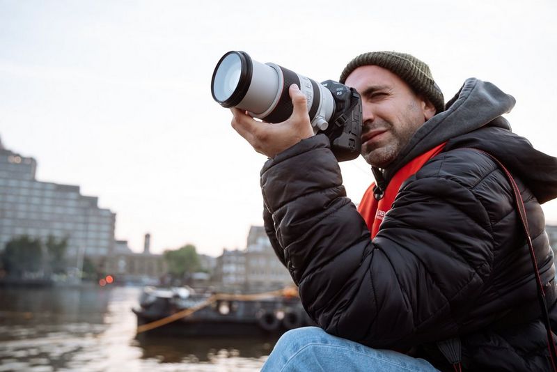 Photographer Alexandros Grymanis holds a Canon EOS R3 with RF 70-200mm F2.8 L IS USM lens, ready to capture the climax of the Red Bull Wings Through Tower Bridge event.