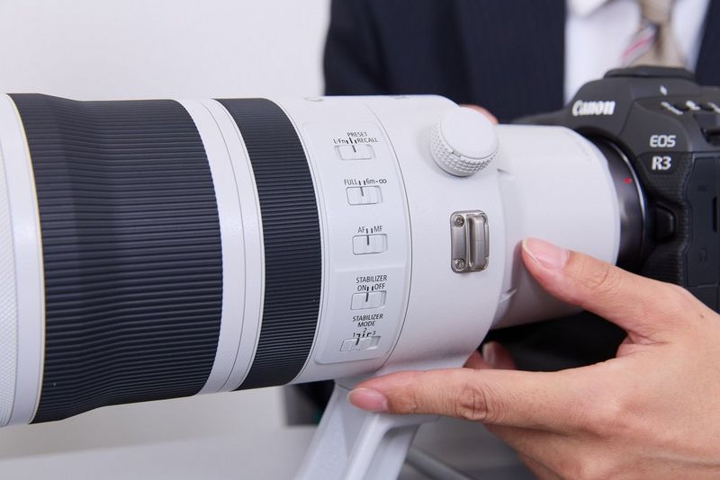 Een hand naast de bedieningselementen aan de zijkant van de tubus van de RF 100-300MM F2.8L IS USM.