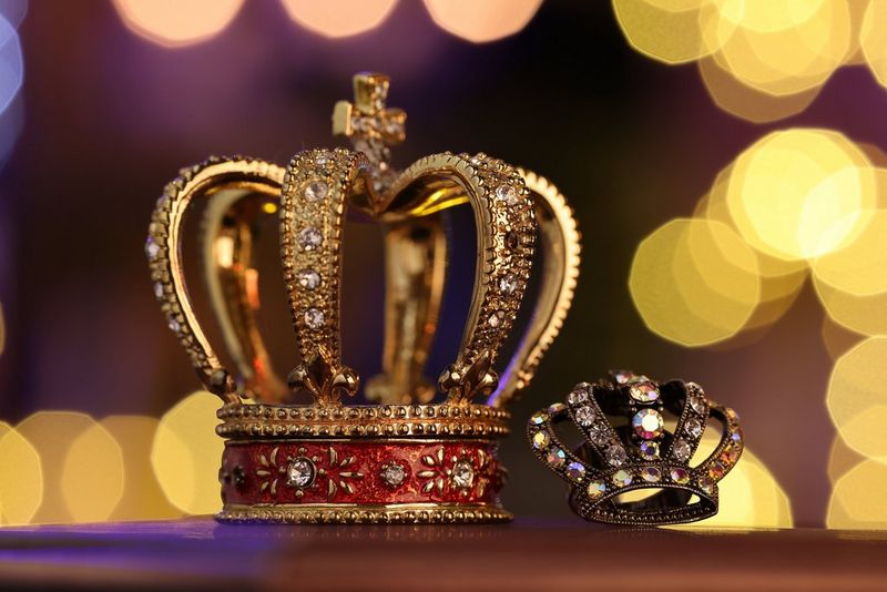 Dve ozdobené koruny, jedna väčšia a jedna menšia, na pozadí veľkého kruhového bokehu.