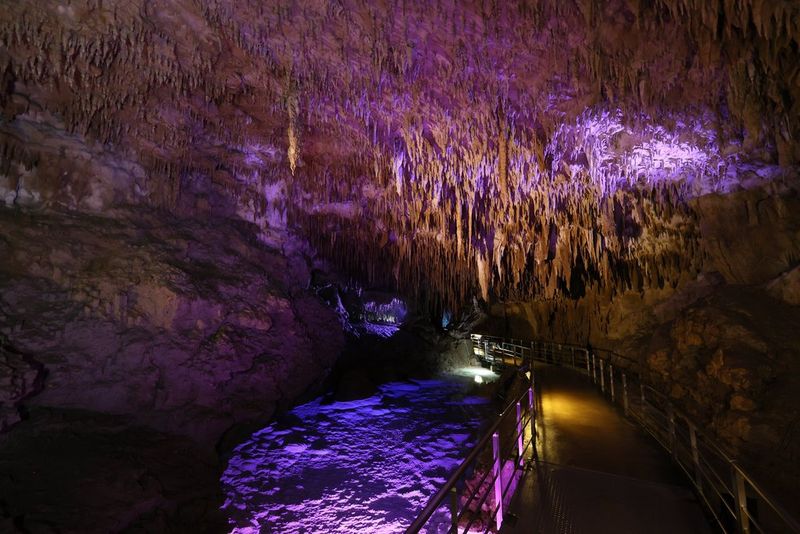 Photo prise avec un objectif Canon RF 15-30mm F4.5-6.3 IS STM dans des conditions de faible luminosité dans une grotte éclairée par des lumières de différentes couleurs.