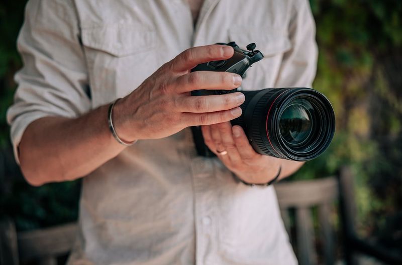 Een gebruiker staat op het punt een Power Zoom-adapter PZ-E2 te bevestigen aan een Canon RF 24-105mm F2.8L IS USM Z-objectief.