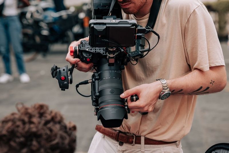 Een filmmaker gebruik een Canon-camera met een externe monitor, een Canon RF 24-105mm F2.8L IS USM Z-objectief en een Canon-zoomgrip ZSG-C10.