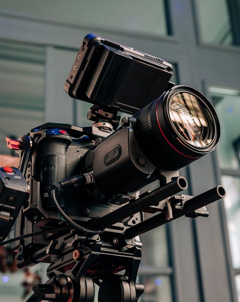 Een beeld waarbij van onder een statief omhoog wordt gekeken. Op het statief staat een Canon-camera met een Canon RF 24-105mm F2.8L IS USM Z-objectief waarop een Power Zoom-adapter PZ-E2B is bevestigd.