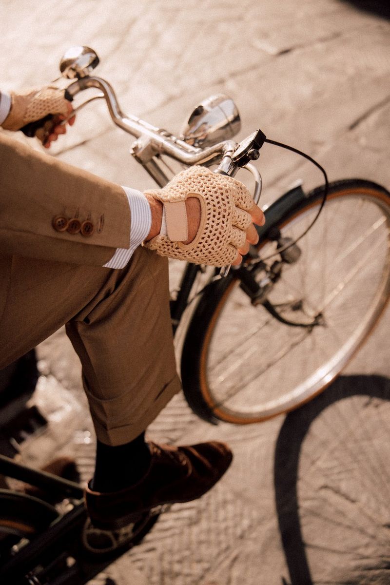 A besuited man riding a bicycle, their arms, leg and the bike's handlebars and front wheel in shot, in a photo captured with a Canon RF 24-105mm F2.8L IS USM Z lens.