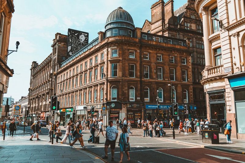 Оживленная улица в солнечный день, заполненная офисными работниками и туристами. Снято Андресом Макнилом с помощью объектива Canon RF 28mm F2.8 STM.