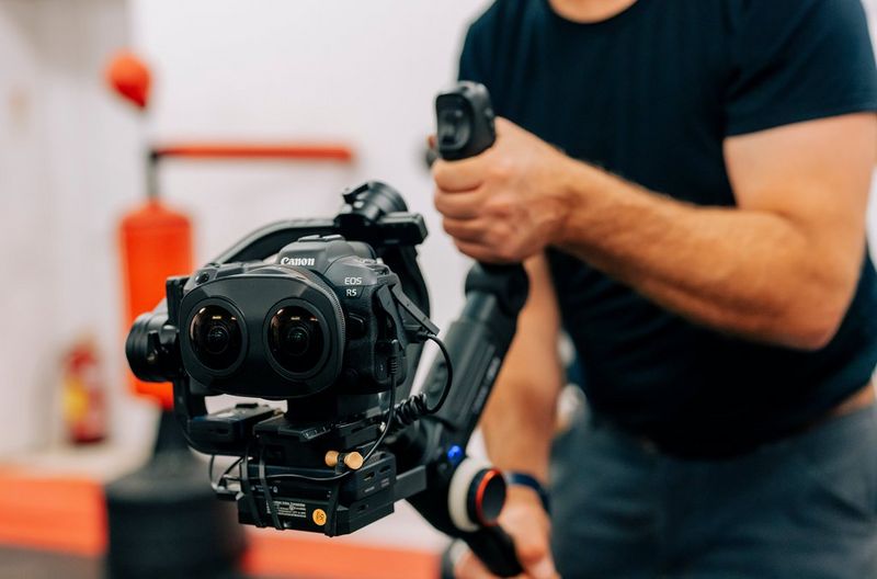 Un homme utilisant un appareil photo Canon EOS R5 équipé d'un objectif Canon RF 5.2mm F2.8L Dual Fisheye.