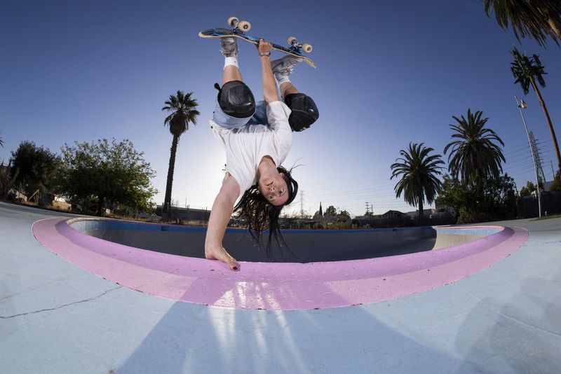 A fisheye photo of a skateboarder performing a handplant in Los Angeles, taken at close range using a Canon RF 7-14mm F2.8-3.5L FISHEYE STM lens.