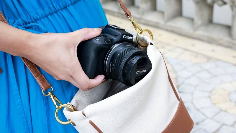 Человек достает из сумки камеру Canon с объективом Canon RF-S 10-18mm F4.5-6.3 IS STM.