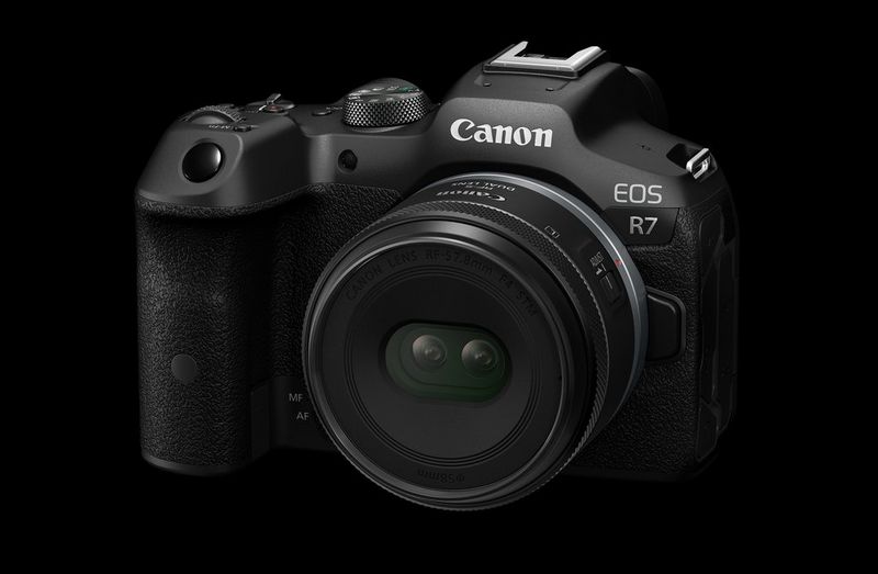 Een Canon EOS R7-camera met Canon RF-S 7.8 mm F4 STM DUAL-lens tegen een zwarte achtergrond.