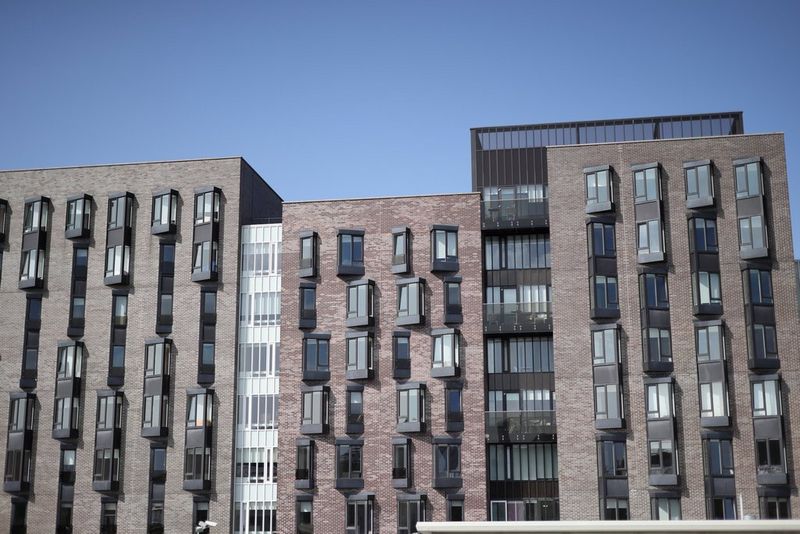 Several buildings with protruding windows shot from the front on a sunny day.