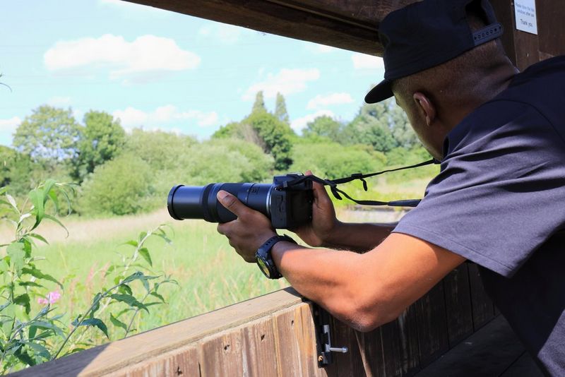 Bird enthusiast Ollie Olanipekun supports a Canon EOS R100 with a Canon RF 75-300mm F4-5.6 lens on a bird hide window ledge.
