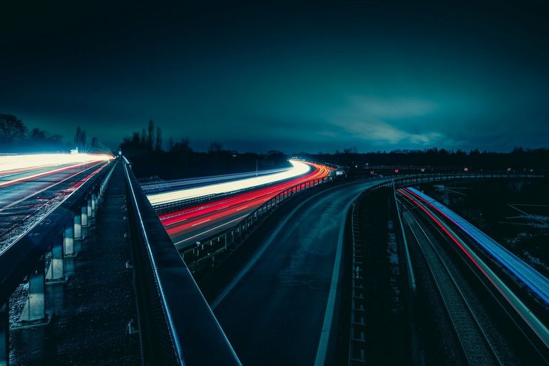 חשיפה ארוכה של רכבים בתנועה  יוצרת שובלי אור אדומים ולבנים לאורך הכביש העמוס.