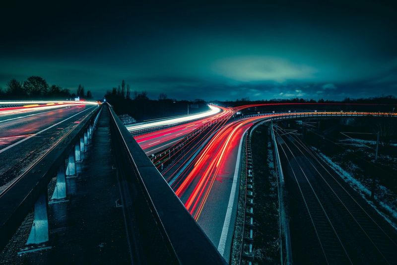 Light trails on a motorway, with two overlapping bridges in evening light. Taken by Lorenz Holder on a Canon EOS R6.