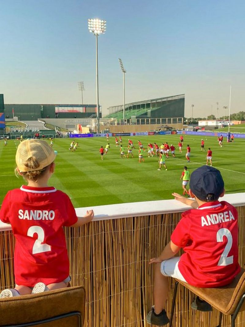 Two young boys, Sandro and Andrea Tadjer, watch from the sidelines of a rugby pitch