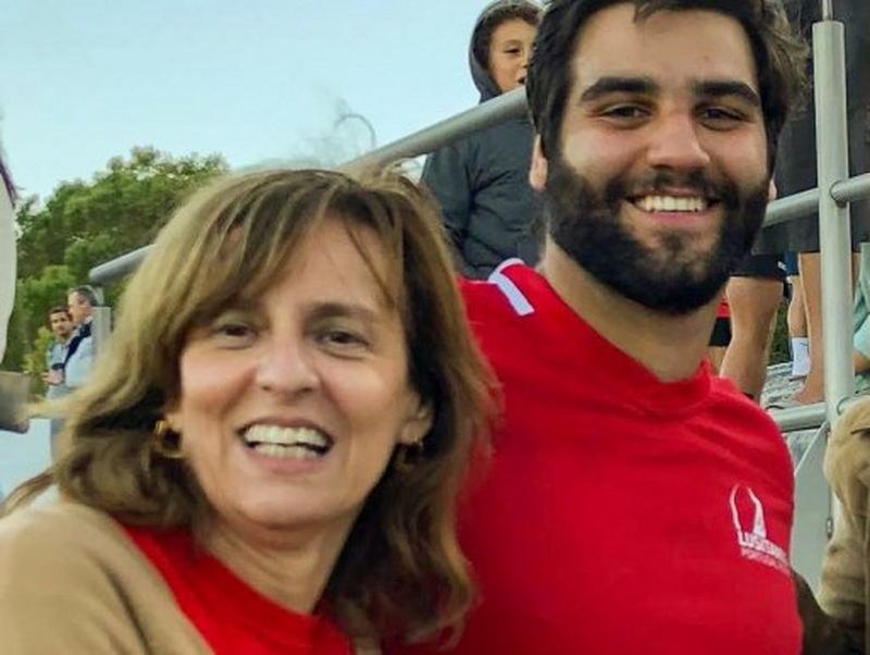 João Granite, wearing a red Portugal jersey, and his mother smile at the camera