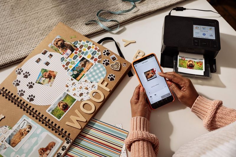 Met een Canon SELPHY CP1500-printer wordt een foto geprint. Er ligt een aantal geprinte familiefoto's naast.