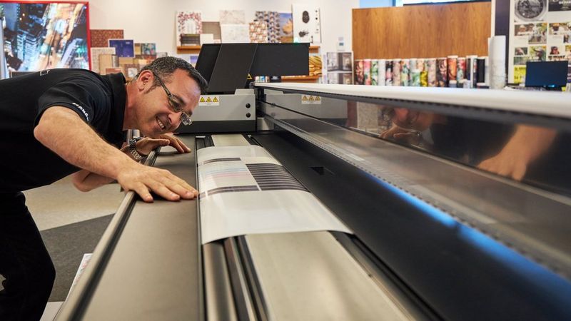 A Canon engineer inspects the output quality from a large-format Canon printer.