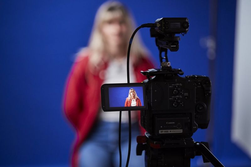 Een persoon wordt scherp weergegeven in het LCD-scherm van een Canon EOS C70, en onscherp voor de camera.