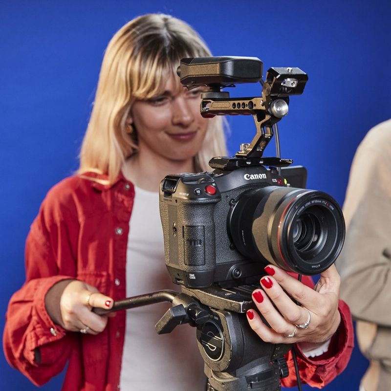 Een Canon EOS C70 op een statief met een Canon RF 50mm F1.2L USM-objectief, die wordt gebruikt als podcastcamera voor een filmische video.