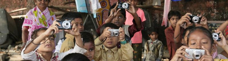  Little children in a group, holding their Canon cameras up to take a photo.