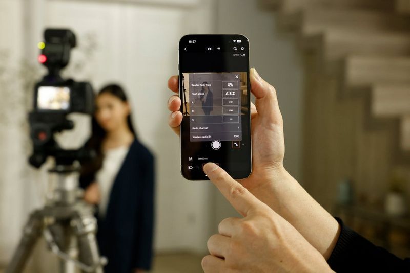 Een fotograaf gebruikt de Canon Camera Connect-app op een smartphone om een Canon Speedlite EL-10 te bedienen voor portretfotografie met flits.