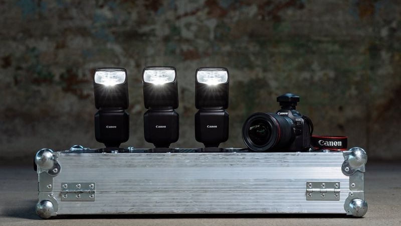 Tre flash Canon Speedlite EL-5 e una fotocamera Canon EOS R6 Mark II, allineati sopra una valigetta da trasporto in acciaio.