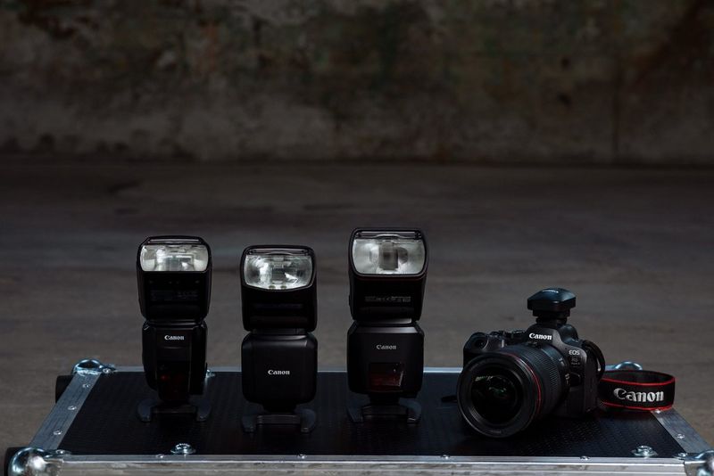 Een Canon Speedlite 600EX II-RT, Speedlite EL-5, Speedlite EL-1 en een Canon EOS R6 Mark II liggen naast elkaar.