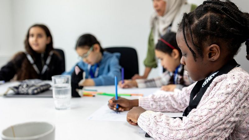 Children of ten and under, sat at a table, carefully drawing. They are all wearing lanyards with ‘Stemettes’ printed on them