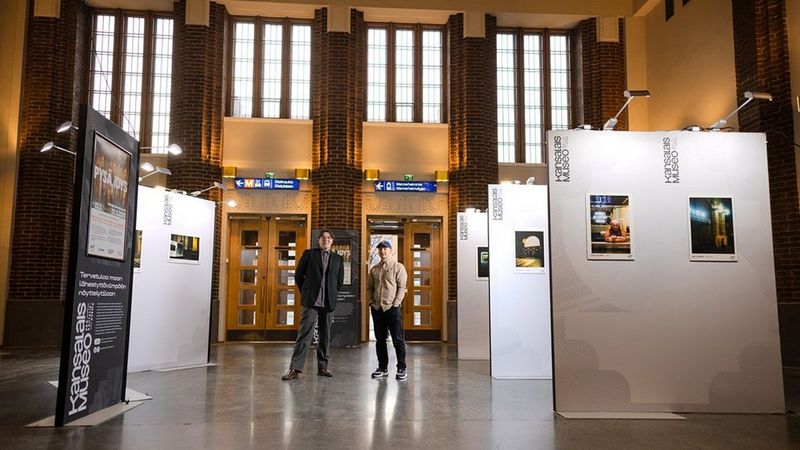 Haastatellut henkilöt seisovat valokuvanäyttelyn keskellä. Päärautatieaseman Kansalaismuseo toimi näyttelyn sijaintina.