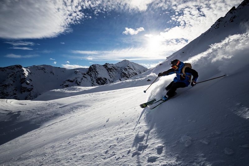 Лыжник едет по горному склону, вздымая в воздух снег. Снято на камеру Canon EOS-1D X Mark II. © Рихард Вальх