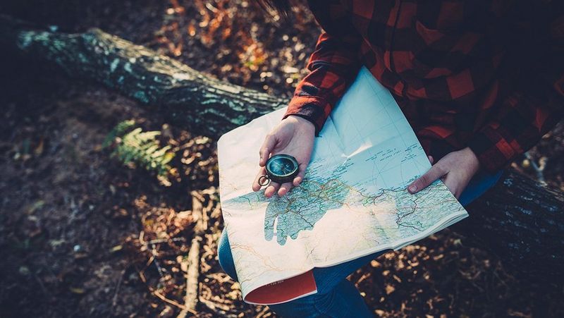 Hand with compass on map