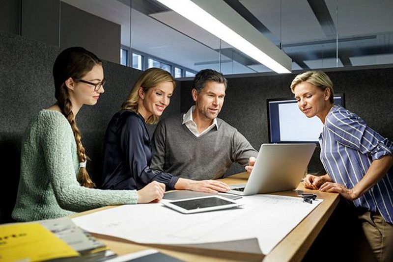 office workers sitting around table discussing work