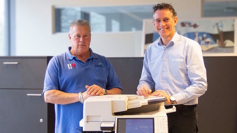 Service engineer en schoonmaker lachend bij multifunctional