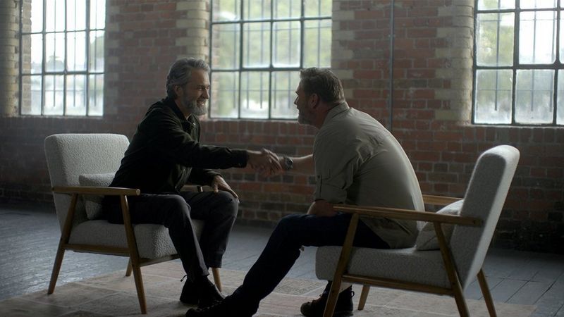 Brent Stirton and Lawrence Gunther sitting down shaking hands