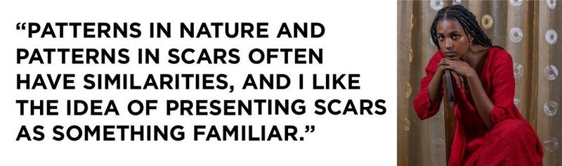 Left: a quote that reads: “Patterns in nature and patterns in scars often have similarities, and I like the idea of presenting scars as something familiar.” On the right, a portrait of Yagazie Emezi, wearing a red dress and sitting sideways on a chair with her hands resting on the back of the chair and her chin resting on her hands. In the background are curtains decorated with doughnut-shaped patterns.