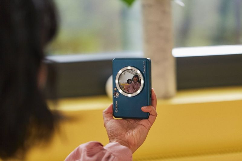 Женщина делает селфи с помощью Canon Zoemini S2.