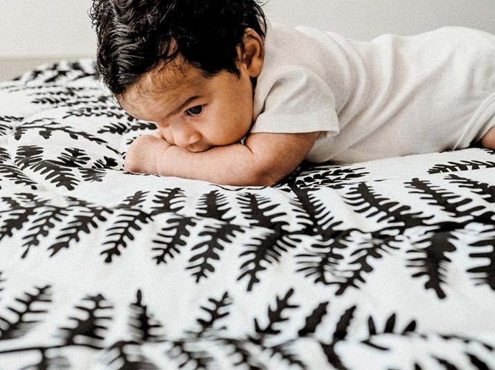 Baby led on a blanket with a high contrast Etta Loves pattern